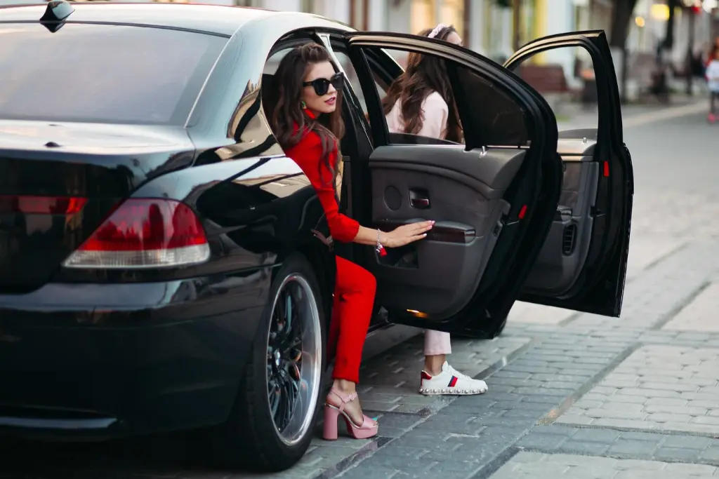 two girls getting out luxury BMW transfer service street